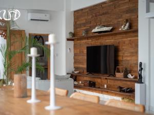 Una sala de estar con un televisor en una pared de madera. en Ama Wela Living Labuan Bajo, en Mbura 49 fotos más