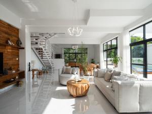 una sala de estar con muebles blancos y una escalera de caracol en Ama Wela Living Labuan Bajo, en Mbura