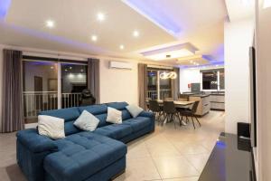 a living room with a blue couch and a kitchen at Luxury Apartment in Gzira close to Sliema 3 BR Apartment Sleep 8 in Il-Gżira