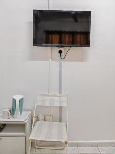 Kota BharuにあるDnRoses Innの壁に椅子とテレビが備わる客室です。