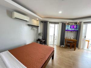 a bedroom with a bed and a table in it at Nadelmar Hotel and Resort in Dalaguete