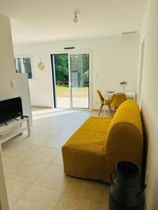 a living room with a yellow couch and a table at La maison dans la prairie gîte marguerite in Saint-Avit-Sénieur +11 photos