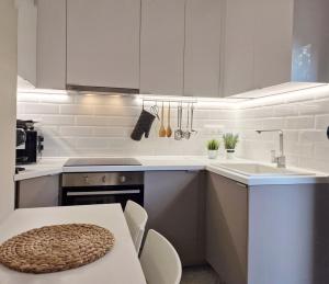 a white kitchen with a table and a sink at Villa Magdalena in Nikiti