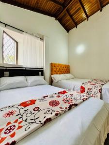 two beds in a room with white walls at CASA FAMILAR frente al parque in Buga
