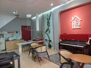 a living room with a red wall and a piano at Redhome Dorm 2 in Thủ Ðức