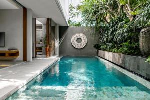 a swimming pool in the middle of a house at Blossom Eco Luxe Villas by Ekosistem in Canggu