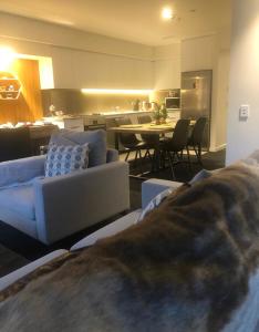 a living room with couches and a kitchen and a table at Modern Luxury Condo Shotover Views in Queenstown