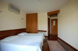 a hotel room with two beds and a hallway at Hotel O Cortiço in Sever do Vouga