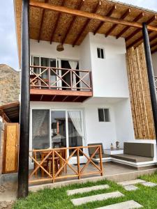 a white house with a balcony and a deck at Rapallo Punta Sal in Canoas de Punta Sal