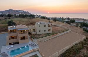 an aerial view of a house with the sunset at Citrus & Fig Villas Your Hidden Paradise in Panormos Rethymno