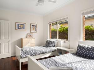 Mango Tree Cottage في ساوتيل: غرفة نوم بها سريرين ونافذة