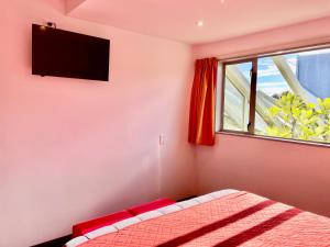 a bedroom with a bed and a tv on the wall at YHA Nelson in Nelson