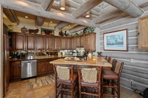 een keuken met houten kasten en een groot eiland met stoelen bij Pine Inn At Trail's End - Three Bedroom W Spa #6 in Park City