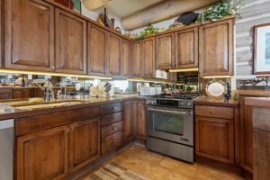 een keuken met houten kasten en een fornuis bij Pine Inn At Trail's End - Three Bedroom W Spa #6 in Park City