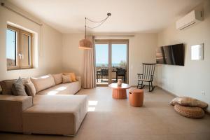 a living room with a couch and a table at Citrus & Fig Villas Your Hidden Paradise in Panormos Rethymno