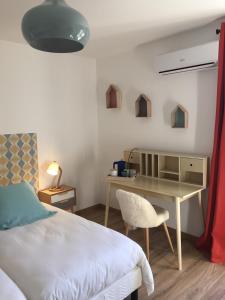 a bedroom with a bed and a table and a desk at B&B Lily et Paul in Bédoin