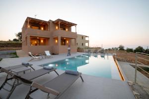 a villa with a swimming pool in front of a house at Citrus & Fig Villas Your Hidden Paradise in Panormos Rethymno