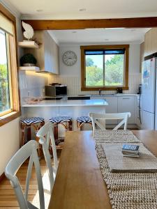 a kitchen with a table and chairs in a room at Spindrift Falmouth, adventurers coastal haven in Falmouth