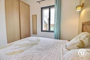 a bedroom with a bed and a window at La source in Plouhinec