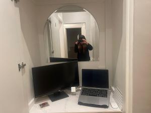 Ein Mann fotografiert einen Computer und einen Laptop. in der Unterkunft Pretty period property sleeps 4 guests with shared garden in Worthing