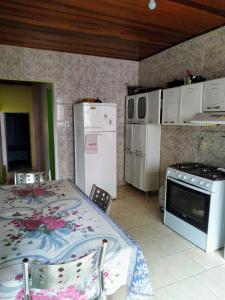 a kitchen with a table and a stove and refrigerator at Espaço Sinara in Jaraguá