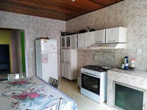 a kitchen with a stove and a refrigerator and a table at Espaço Sinara in Jaraguá