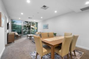 Un comedor y una sala de estar con mesa y sillas. en Belle Escapes - Coast on Colley Terrace, en Glenelg
