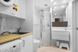 Un baño con lavabo, inodoro y ducha. en Belle Escapes - Coast on Colley Terrace, en Glenelg 39 fotos más