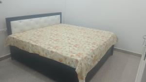 a bed in a room with a table with a flowered sheet at Hotel Harihar Atithi Bhawan in Naimishāranya