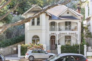a white house with a car parked in front of it at The Darling Private Oasis with Heated Magnesium Pool in Sydney