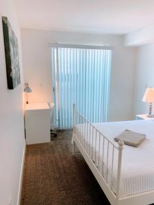 a white bedroom with a crib and a large window at Western Melrose in Los Angeles