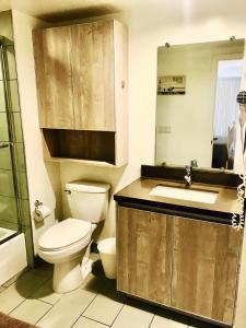 a bathroom with a toilet and a sink and a mirror at Western Melrose in Los Angeles