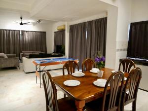 a dining room and living room with a table and chairs at Homestay Cozy PD Villa, Port Dickson in Port Dickson