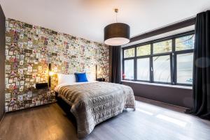 Schlafzimmer mit einem Bett und einer mit Fotografien bedeckten Wand in der Unterkunft Smartflats Design - Berlaymont in Brüssel