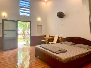 ein Schlafzimmer mit einem Bett und einem Tisch mit Stühlen in der Unterkunft ML Homestay in Bình Châu