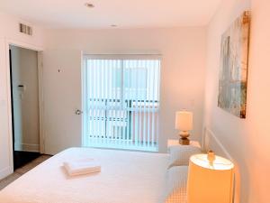 a bedroom with a white bed and a large window at Western Lemon Grove in Los Angeles