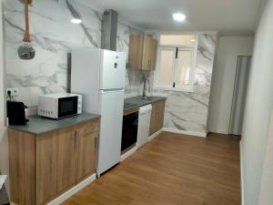 a kitchen with a white refrigerator and a microwave at Apartament El Colomer 3 habitacions in Simat de Valldigna