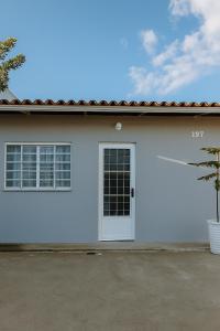 a white house with a door and a palm tree at A 10 minutos do maior Natal luz de Pe in Garanhuns