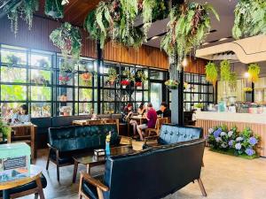 Menschen sitzen in einem Restaurant mit Tischen und Stühlen in der Unterkunft IP Plus Pool Villa Pattaya in Jomtien Beach