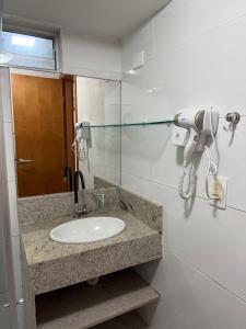 ein Badezimmer mit einem Waschbecken und einem Haartrockner in der Unterkunft Israel Flat beira-mar in João Pessoa + 14 Fotos
