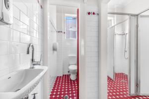 un bagno con un water e una vasca e un pavimento rosso di Stay Today Hostel a Sydney