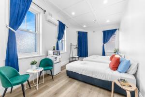 una camera da letto con un letto e due sedie verdi di Stay Today Hostel a Sydney
