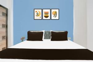 a bedroom with a white bed and a blue wall at Super Hotel O Dream Palace in Delhi