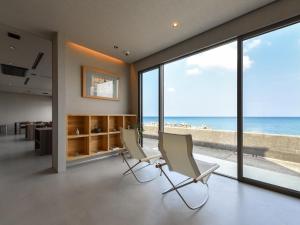 two chairs in a living room with a view of the beach at Hashimotoya in Himi