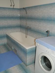 ein Badezimmer mit einer Badewanne und einer Waschmaschine in der Unterkunft Bartulovi dvori in Poljica