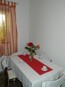 a table with a red napkin and a vase of flowers on it at Bartulovi dvori in Poljica
