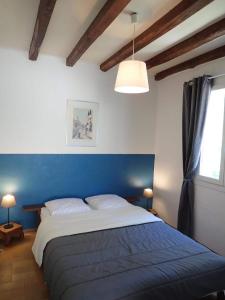 ein Schlafzimmer mit einem großen Bett mit blauem Kopfteil in der Unterkunft Domaine de Ravel Ushuaïa Villages in Saint-Jean-du-Gard