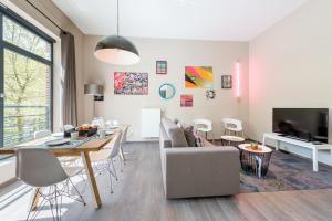 ein Wohnzimmer mit einem Tisch und einem Esszimmer in der Unterkunft Smartflats Design - Berlaymont in Brüssel