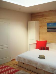 una camera con letto e cuscino rosso di Le Relais de la Praya a Lège-Cap-Ferret