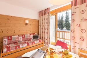 Zimmer mit einem Bett, einem Tisch und einem Fenster in der Unterkunft Résidence Pierre & Vacances Le Golf in Méribel